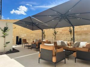 a patio with couches and chairs under a large umbrella at Palazzo Giusti Lecce - Exclusive Boutique hotel in Lecce