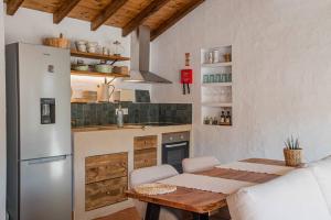 a kitchen with a table and a refrigerator at Casa da Azeitona T1 - Monte do Serrado de Baixo in Évora