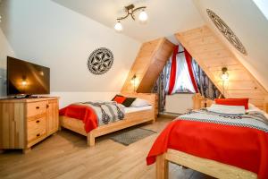 a bedroom with two beds and a flat screen tv at Czarna Turnia -ZAKOPANE in Zakopane