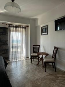 a living room with chairs and a table and a window at Leeon seaside in Myrina +19 photos