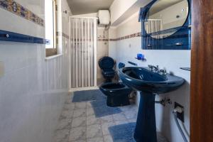 a bathroom with a blue sink and a toilet at Casa vacanze da Nicola in Saponara Villafranca +20 photos
