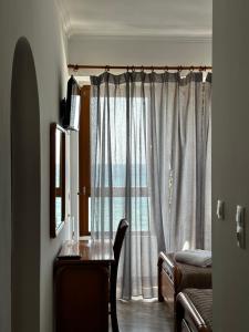 a room with a window with a table and a mirror at Leeon seaside in Myrina
