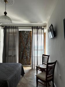 a bedroom with a bed and two chairs and a window at Leeon seaside in Myrina