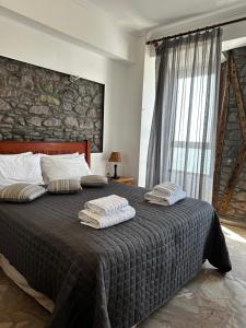 a bedroom with a large bed with two towels on it at Leeon seaside in Myrina