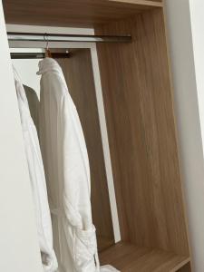 ein Schrank mit weißen Hemden an einer Stange in der Unterkunft Riviera Hotel-City Center in Vlorë