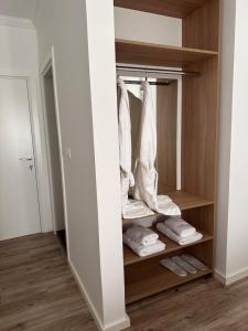 a walk in closet with wooden shelves and towels at Riviera Hotel-City Center in Vlorë +14 photos