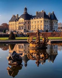 a large building with a fountain in the water in front at Charmante studio ligne 13 tram 5 saint denis in Pierrefitte-sur-Seine