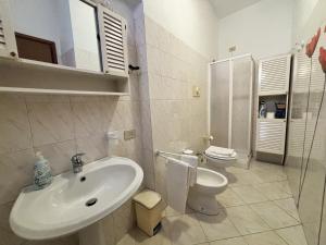 a white bathroom with a sink and a toilet at La Casetta - tranquillo in pieno centro - con garage in Cremona +7 photos