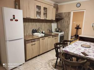 a kitchen with a table and a white refrigerator at bsapartman in Tiszaújváros