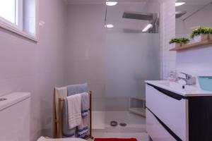 a white bathroom with a sink and a bath tub at Perafita Yellow House - EcoHost in Perafita +23 photos