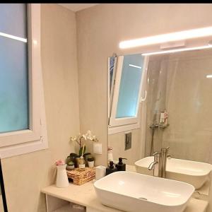 a white bathroom with a sink and a mirror at Terranova beach apartment -Rose in Ýpsos