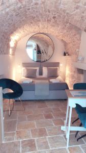 a bedroom with a bed and a mirror and a table at Cà Bella Vista in Ostuni