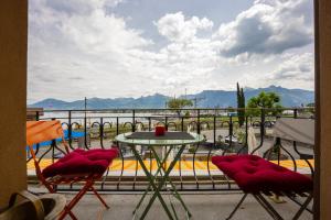 a table and chairs on a balcony with a view of the water at Le Dock in Port-Valais
