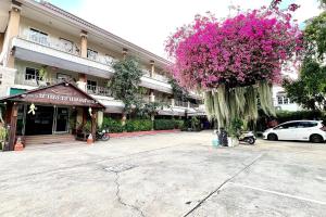 a large tree with pink flowers in front of a building at Nan Thara Place in Nan