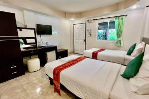a hotel room with two beds and a television at Nan Thara Place in Nan
