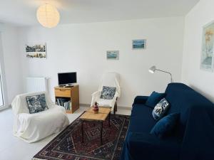 un salon avec un canapé bleu et deux chaises dans l'établissement 3 pièces 68m², jardin clos, 150m plage, wifi, à Saint-Pierre-Quiberon