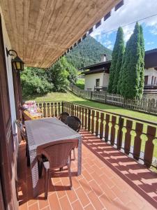 a patio with a table and chairs on a balcony at Appartamento 3 Cime - Vicino al Centro in Auronzo di Cadore