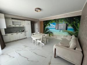 a kitchen and living room with a table and a couch at TUDOR BY DEDAL APARTHOTEL in Năvodari