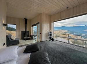 a bedroom with a bed and a large window at Magurka Space in Verkhovyna