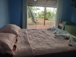 a bedroom with a large bed with a window at Pousada Grão in Belém