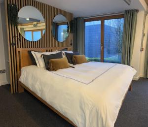 a bedroom with a large white bed with two mirrors at Jackie's Place in Wexford