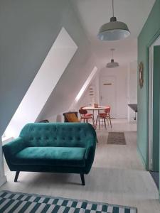 a green couch in a living room with a table at Charmant T3 lumineux à 2 pas des plages Appart 5 in Binic-Etables-sur-Mer