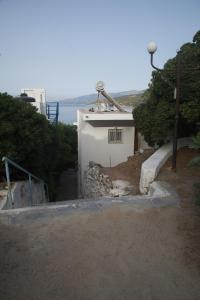 a small white building on the side of a hill at Sufiko Studios - Drosia in Armenistis