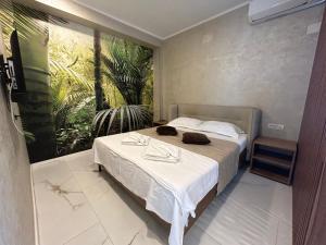 a bedroom with a bed with a painting on the wall at TUDOR BY DEDAL APARTHOTEL in Năvodari
