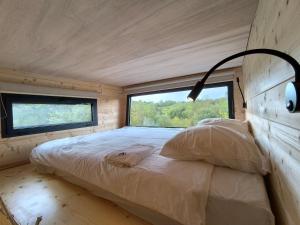 a bed in a small room with a window at Moose Home Tiny house Genêts in Cros