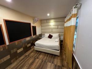 a small room with a bed and a flat screen tv at Parakkat Nature Resort in Munnar