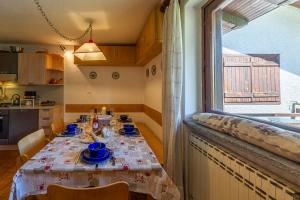 a dining room with a table and a window at MAISON MOULIN - Relax e vista Montagna - LA THUILE 0107 in La Thuile +23 photos