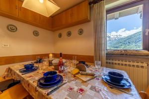 a dining room with a table with plates and glasses at MAISON MOULIN - Relax e vista Montagna - LA THUILE 0107 in La Thuile