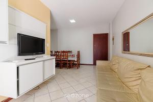 a living room with a couch and a flat screen tv at Apto c/ varanda a 150m do mar em Meia Praia RCB405 in Meia Praia