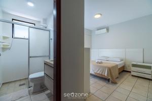a bedroom with a bed and a toilet and a sink at Apto c/ varanda a 150m do mar em Meia Praia RCB405 in Meia Praia +18 photos