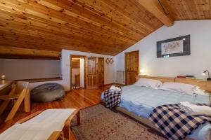 a bedroom with a large bed and a wooden ceiling at MAISON MOULIN - Relax e vista Montagna - LA THUILE 0107 in La Thuile