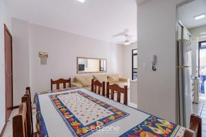 a dining room and living room with a table at Apto c/ varanda a 150m do mar em Meia Praia RCB405 in Meia Praia