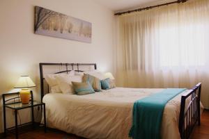 um quarto com uma cama grande e uma janela em Flat Accommodation in Braga em Braga