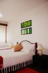Flat Accommodation in Braga في براغا: غرفة نوم بسرير ابيض مع نافذتين