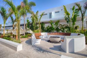 een patio met een bank en stoelen voor een gebouw bij 1BR 2BA | Romantic Zone w/ Rooftop Pool & Gym in Puerto Vallarta