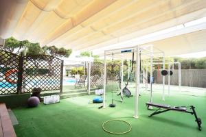 a gym with equipment on a green floor at Hotel Albaida Nature in Mazagón