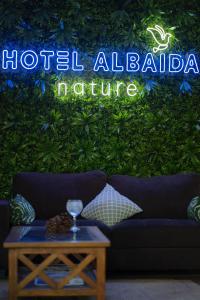 a living room with a couch and a sign that reads hotel alabama nature at Hotel Albaida Nature in Mazagón