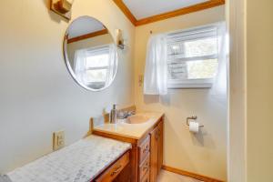 a bathroom with a sink and a mirror at Table Rock Lake Cabin with Deck and Bar! in Shell Knob +17 photos