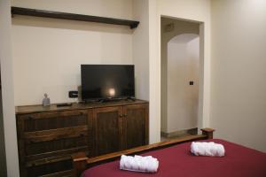 una camera da letto con una tv e un letto con una coperta rossa di Gate 295 a Livorno