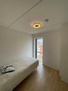 a white room with a bed and a window at Central og rolig lejlighed med gratis parkering in Hedehusene +16 photos