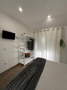 a bedroom with a bed and a tv on a wall at Old Dream in Nazaré