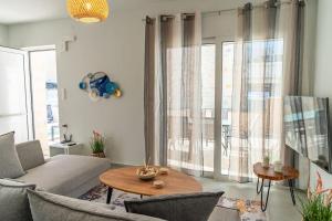 a living room with a couch and a table at Armonia Suite in Panormos Rethymno