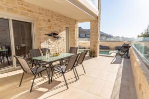 a patio with a table and chairs on a balcony at Armonia Suite in Panormos Rethymno