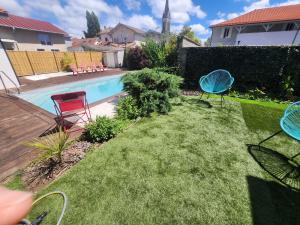 a yard with two chairs and a swimming pool at Maison plein centre - Piscine in Mimizan