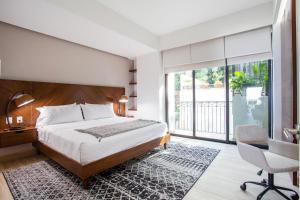 a bedroom with a bed and a desk and a chair at Ocean-View Backdrop and Private BBQ, Upscale 2 BR in Puerto Vallarta +19 photos