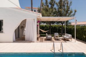 a swimming pool with a pavilion and a swimming pool at BiniVento- Lovely villa with pool near the beach in Binibeca